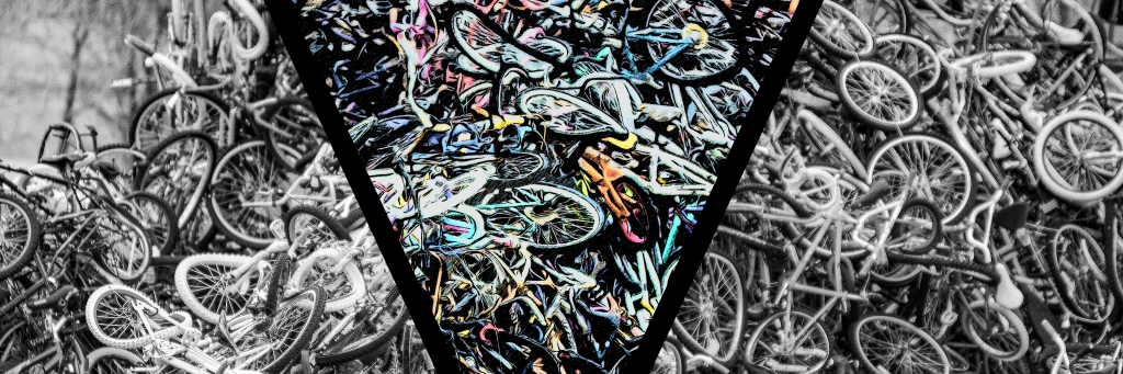 Hundreds of discarded bikes are heaped in a pile, their frames and wheels disfigured but recognizable. The image is in black and white, with a V cut through the center. Inside the V, the bikes appear to be painted in vivid colors.